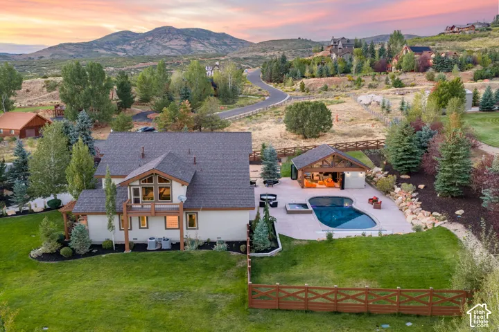 Expansive backyard featuring a manicured lawn, a freeform swimming pool, and an integrated spa