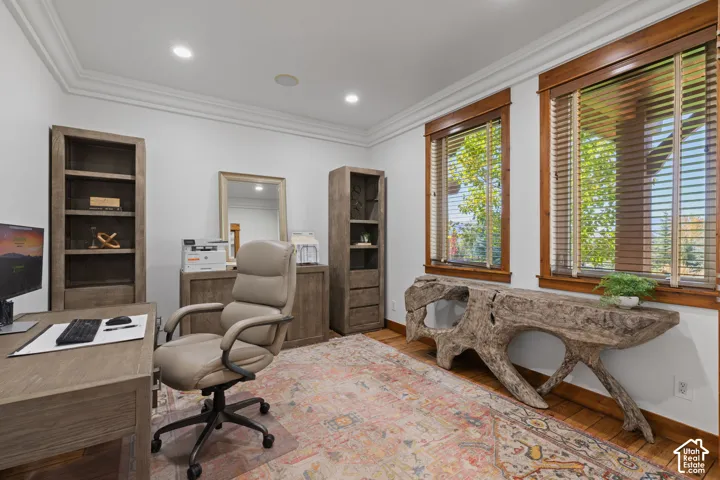 Hardwood flooring, recessed lighting, crown molding, and wood-framed windows with blinds