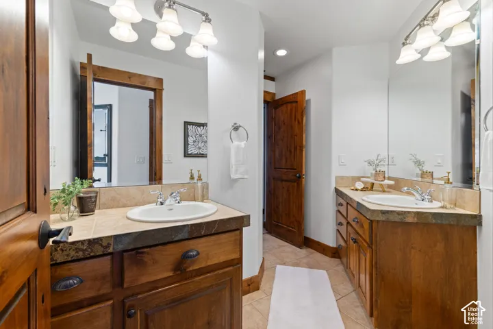 Dual wood-finish vanities with tile countertops and integrated sinks