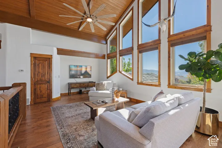 Vaulted wood-paneled ceiling, exposed wood beams, hardwood flooring, and abundant natural light from multiple windows