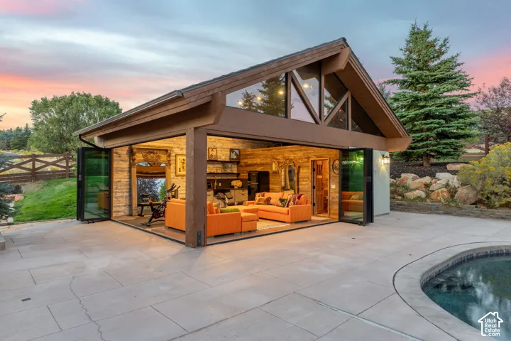 Detached structure with a gabled roof, large glass folding doors, and a wood-paneled interior