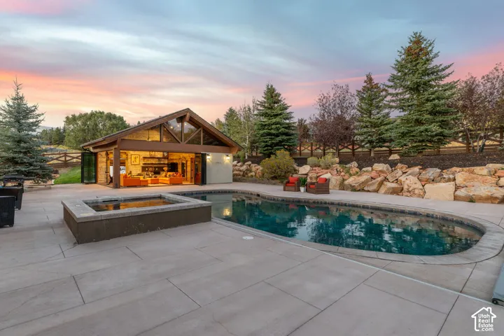 Spacious backyard featuring a built-in swimming pool, integrated hot tub, and large patio