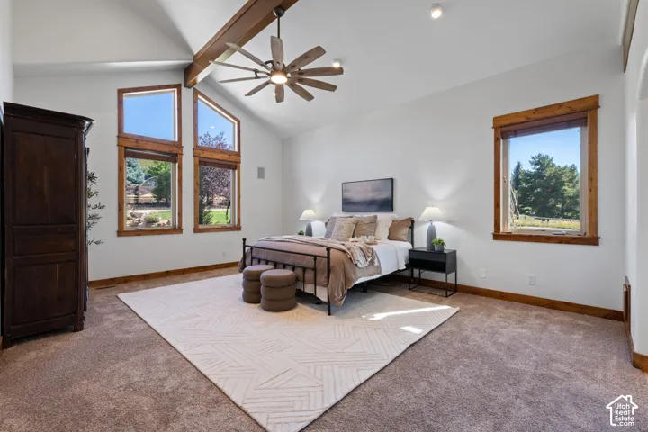 Vaulted ceiling with exposed wood beam, ceiling fan, multiple large windows with wood trim, and recessed lighting
