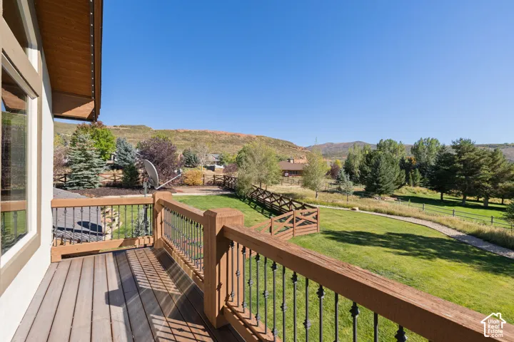 Expansive outdoor deck with wood-finish flooring and wrought iron railings