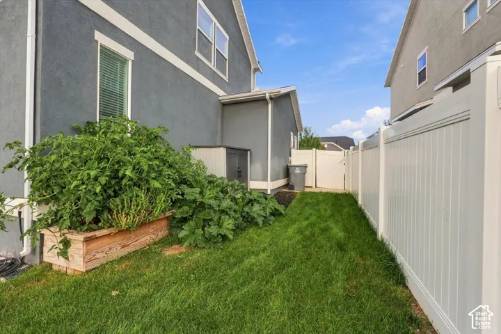 Manicured lawn with a privacy fence and a raised garden bed