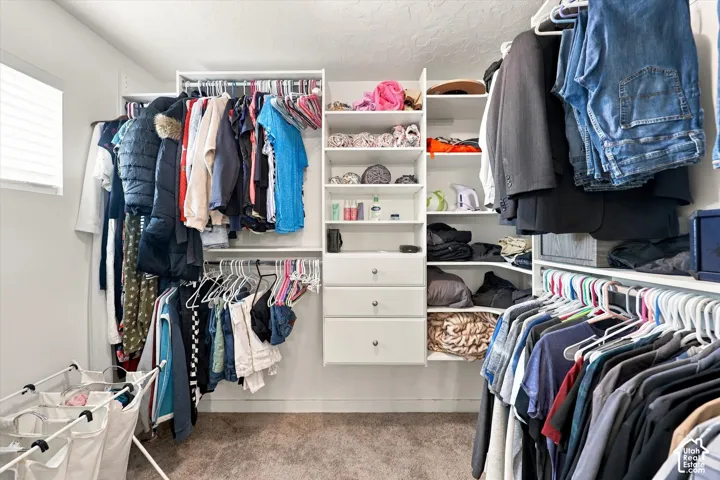 Custom closet organization system with multiple hanging rods, built-in shelving, and integrated drawers