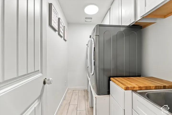 Wood-finish flooring, recessed lighting, built-in cabinetry, and integrated sink with a wood countertop