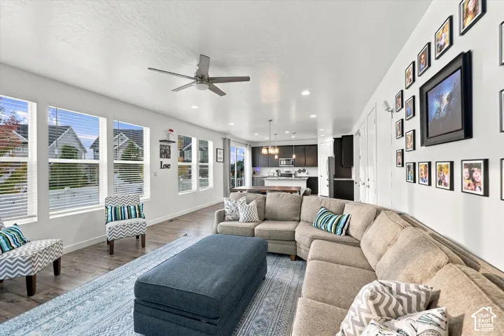 Open-concept living space featuring wood-finish flooring, recessed lighting, and multiple windows