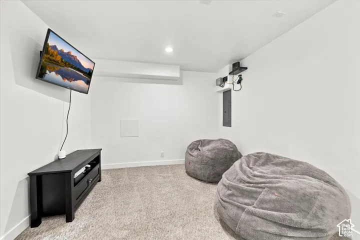 Recessed lighting illuminates the carpeted floor and white walls