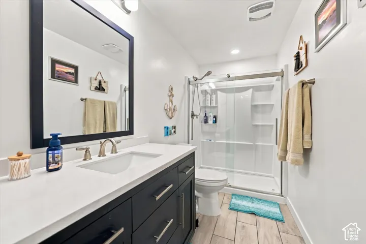 Vanity with a single basin sink, brushed nickel faucet, and dark cabinetry with drawer pulls