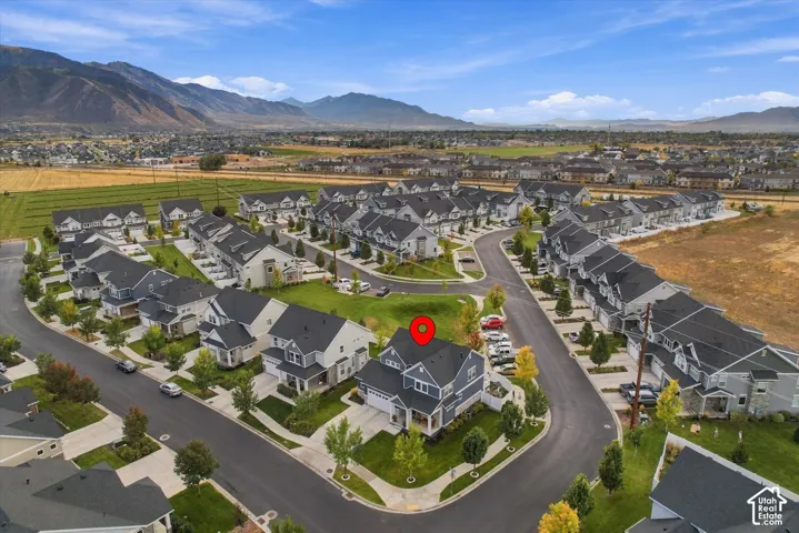 Aerial perspective of a developed residential area with mountain backdrop and open fields