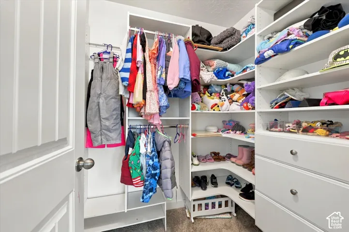 Custom closet system featuring multiple hanging rods, built-in shelving, and drawers with brushed nickel hardware