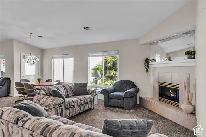 Corner fireplace with tiled surround, multiple windows providing natural light, and a dining area with pendant lighting