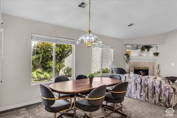 Recessed lighting and a decorative chandelier illuminate the dining area