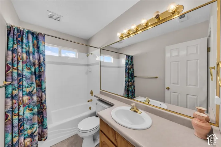 Bathroom featuring a white bathtub, white tile surround, transom window, and a vanity with an integrated sink and large mirror