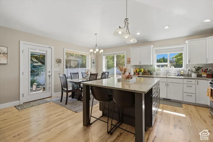 Bright kitchen with white cabinetry and light-toned wood-finish flooring