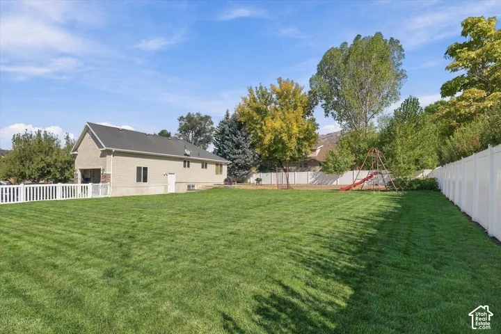 Expansive lawn area, full privacy fencing, and exterior stucco finish