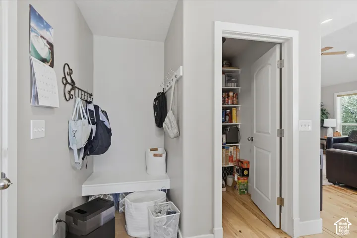 Built-in bench seating with storage, wood-finish flooring, and a pantry with shelving