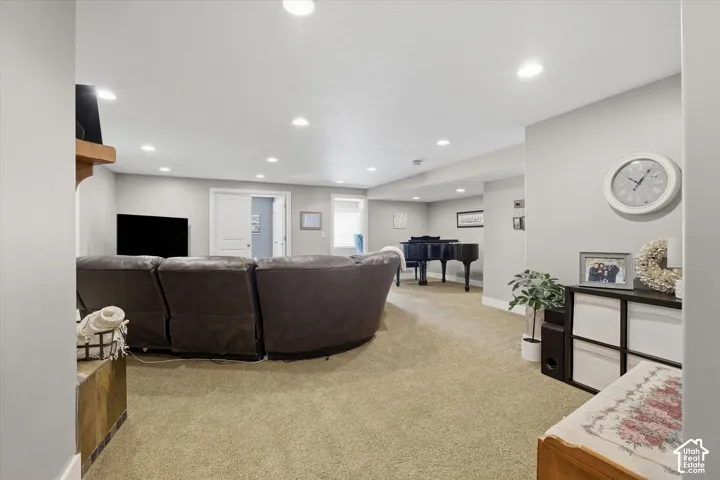 Recessed lighting illuminates the carpeted floor and light-toned walls