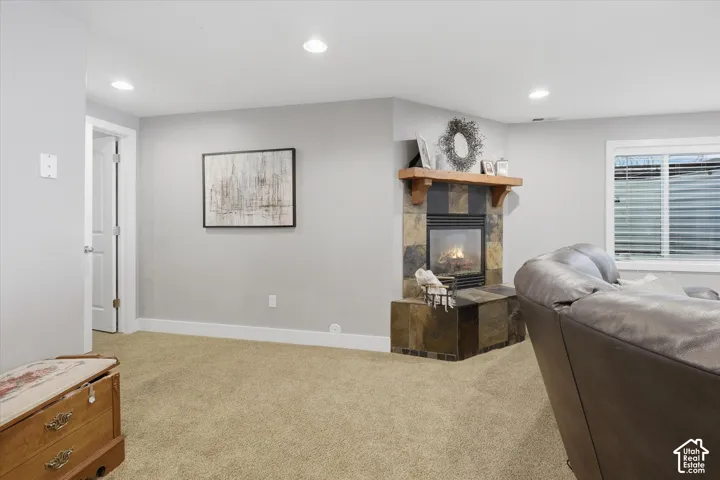 Corner fireplace with a stone surround, wood mantel, and hearth