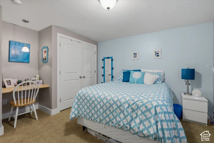 Recessed lighting, built-in desk with pendant light, bi-fold closet doors, wall-to-wall carpeting, and neutral paint colors