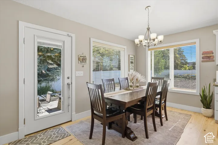 Bright dining room with abundant natural light from multiple windows and a glass door opening to an outdoor patio