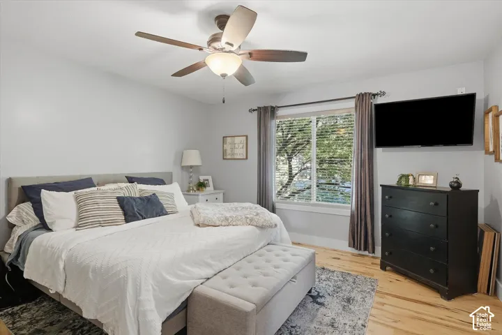 Wood-finish flooring, ceiling fan, and window with blinds