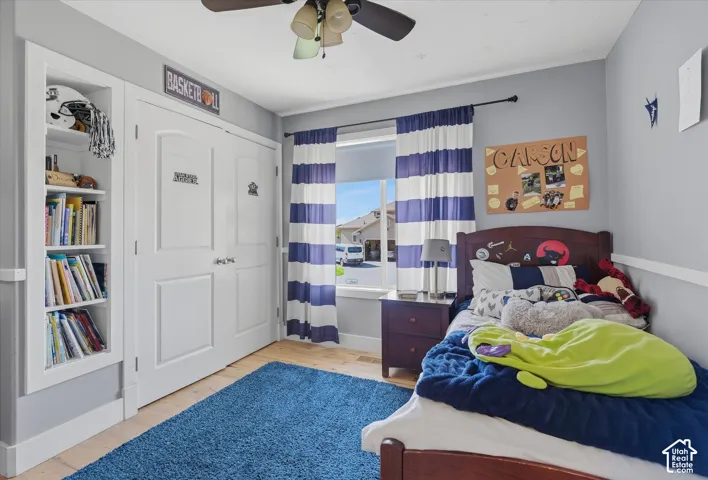 Hardwood-finish flooring, built-in shelving, two-panel interior doors, and a ceiling fan
