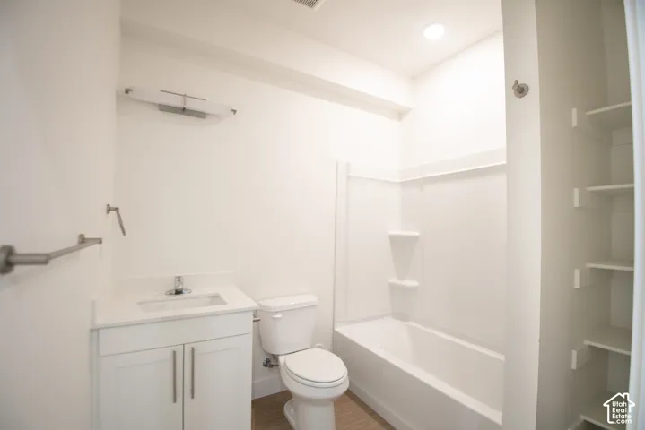 White vanity with shaker-style cabinetry, a white countertop, and a single basin sink