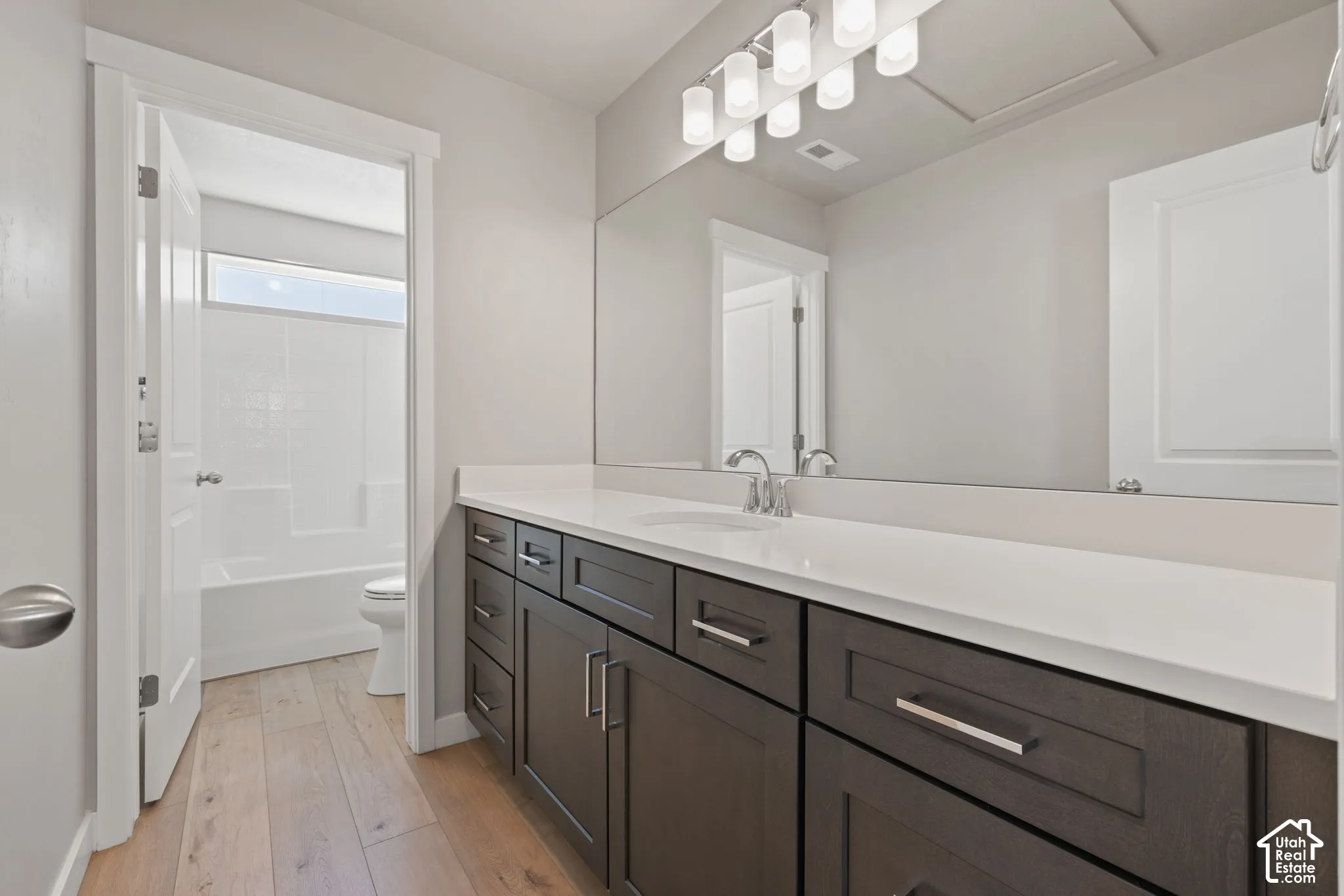 Extended vanity with a white countertop and dark wood-finish cabinetry