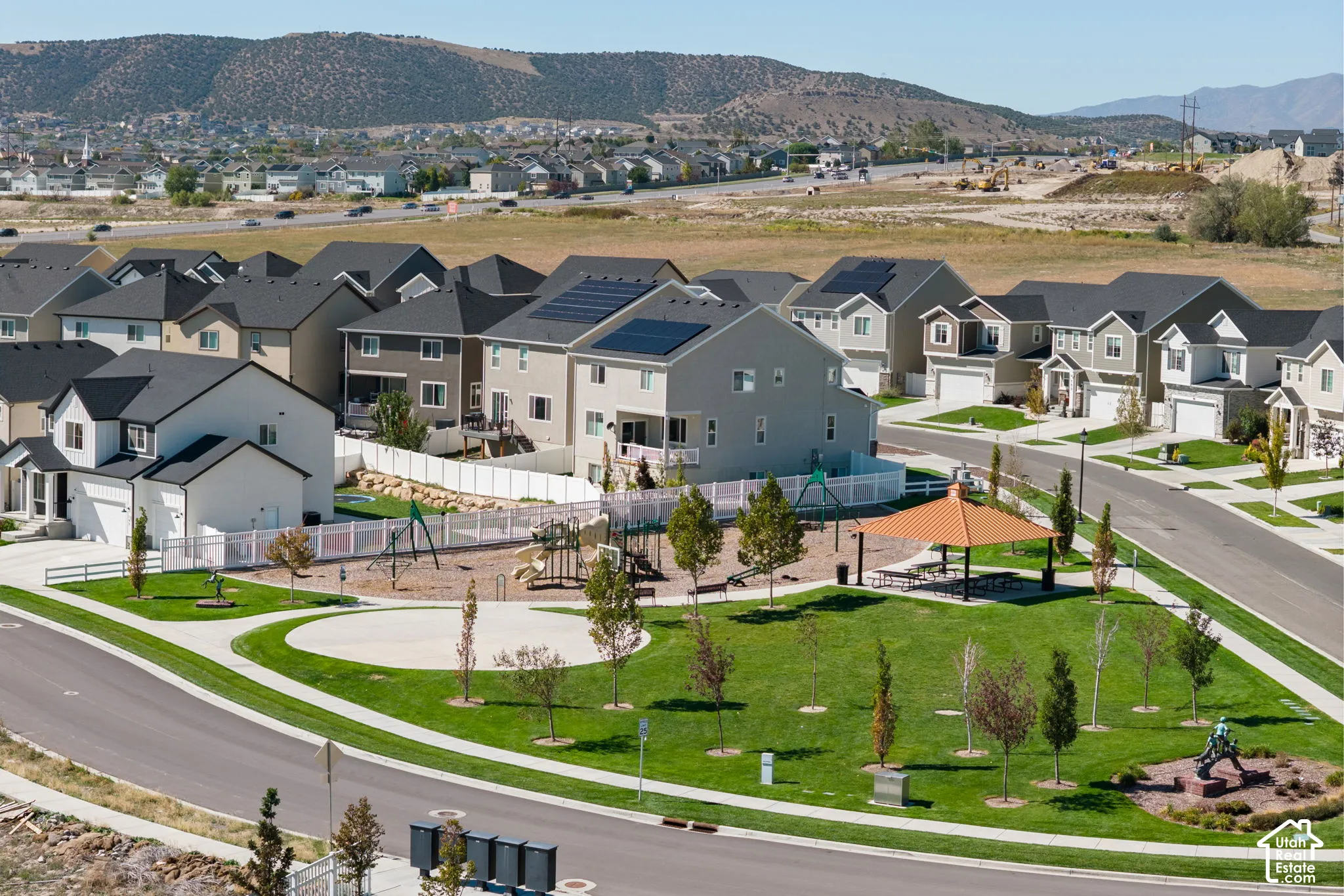 Community park featuring a playground structure, covered picnic area, and manicured green space