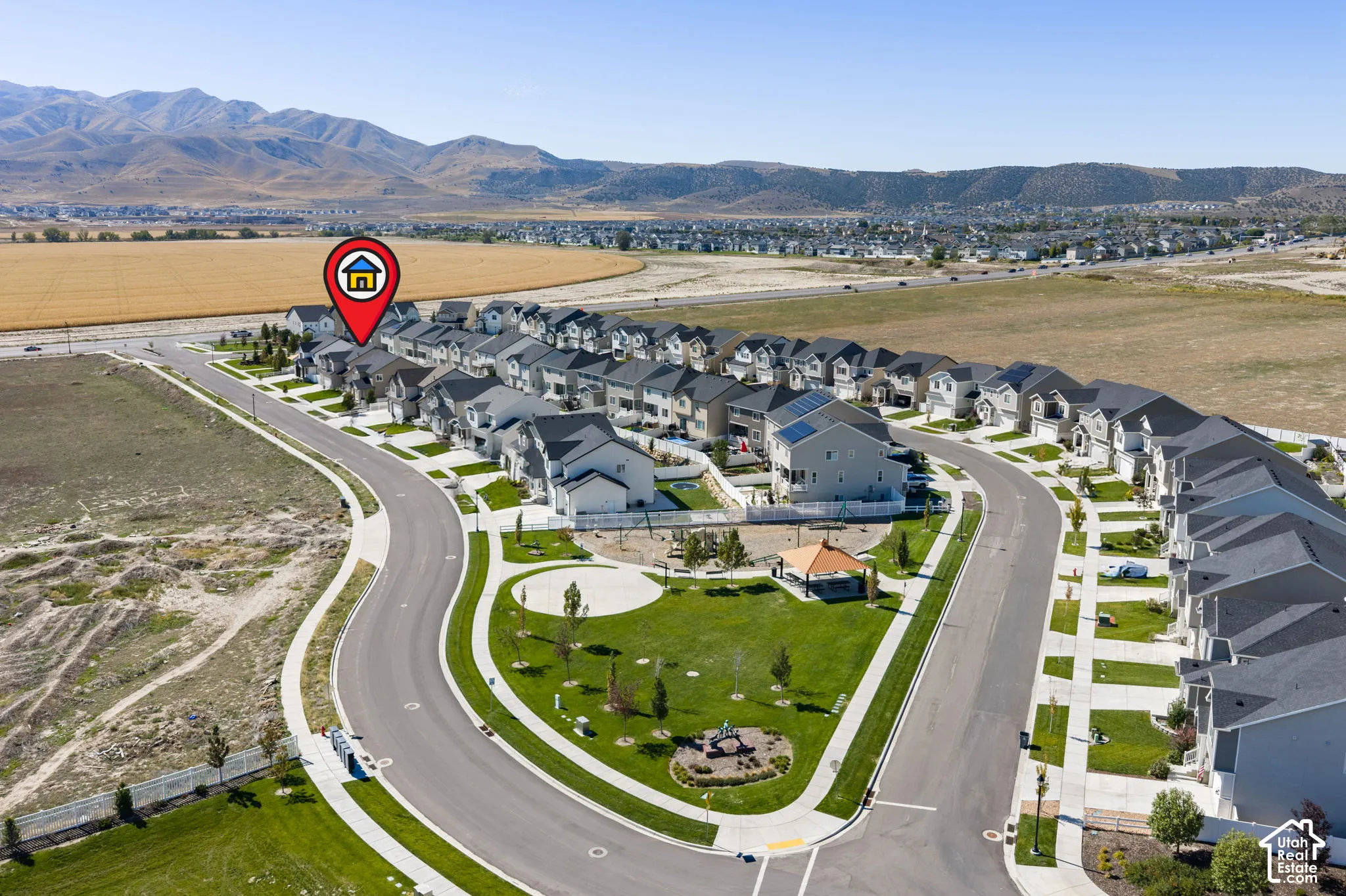 Residential neighborhood with curved roadways, extensive sidewalks, and a central green space featuring a gazebo and playground equipment