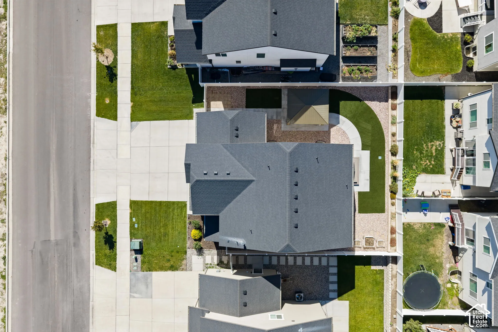 Expansive residential lot featuring a dark-toned roof, paved patio areas, and a dedicated artificial turf section