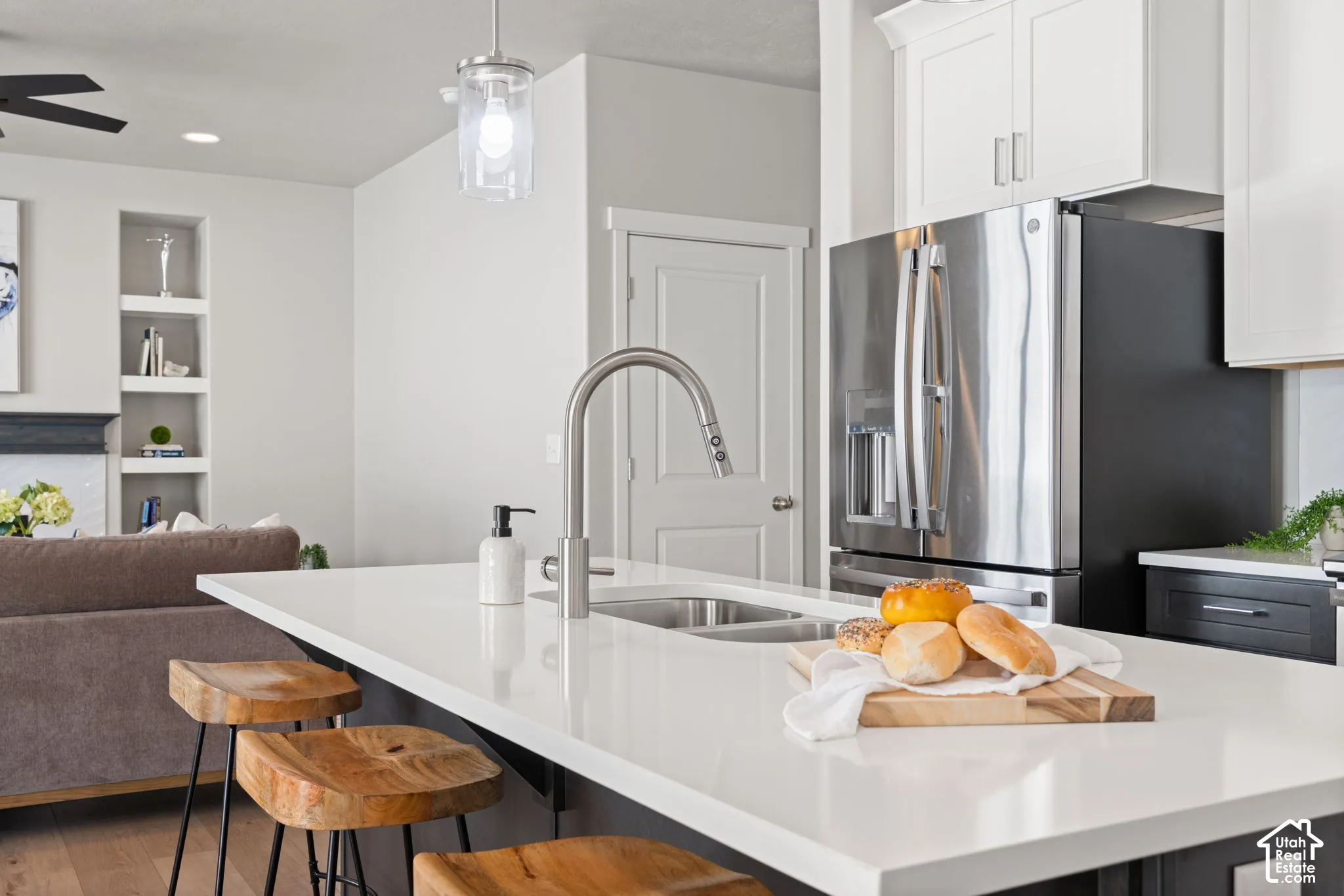 Kitchen island with an undermount sink, gooseneck faucet, and light-toned solid surface countertop
