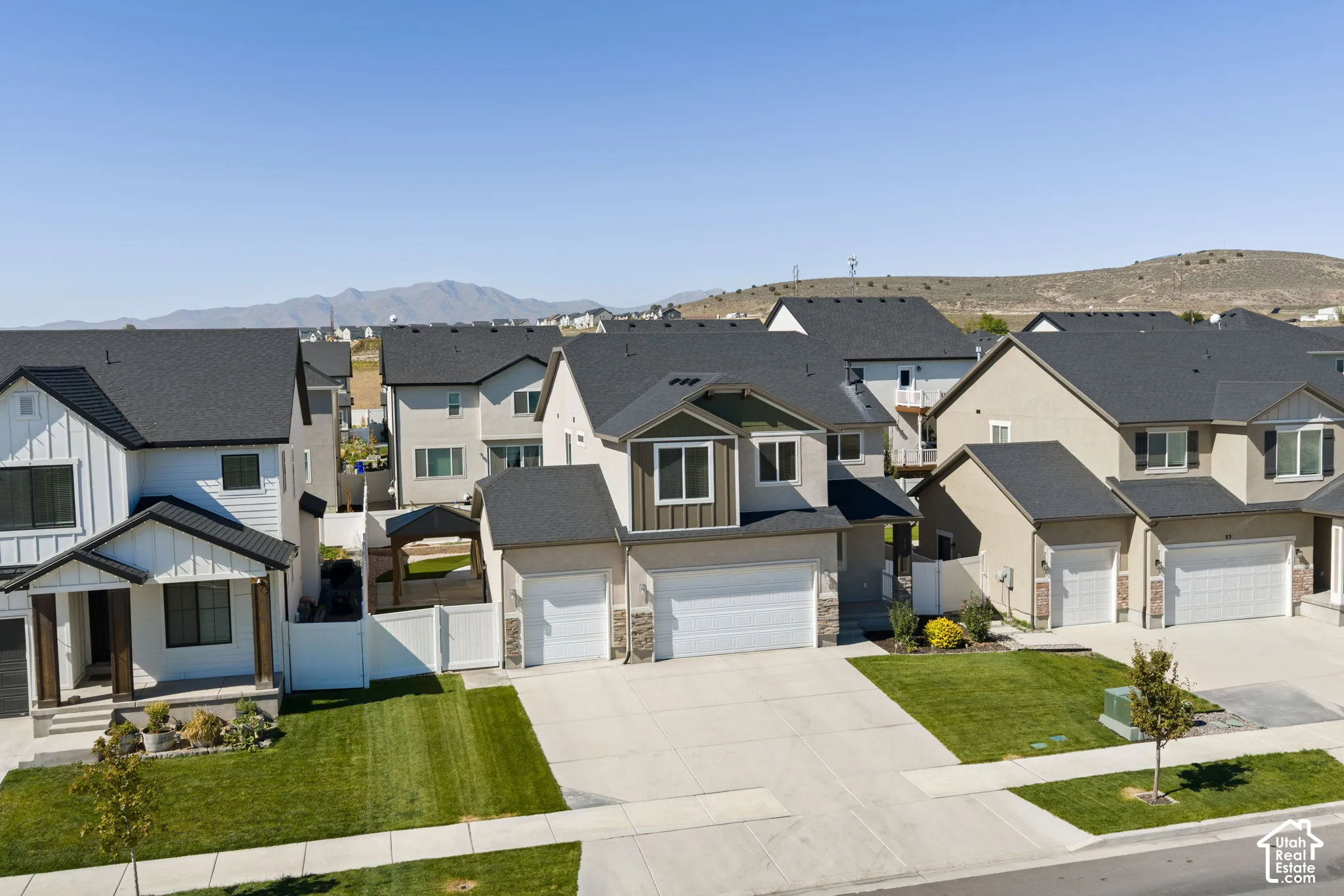 Contemporary two-story residence with a dark shingle roof, attached two-car garage, and a concrete driveway