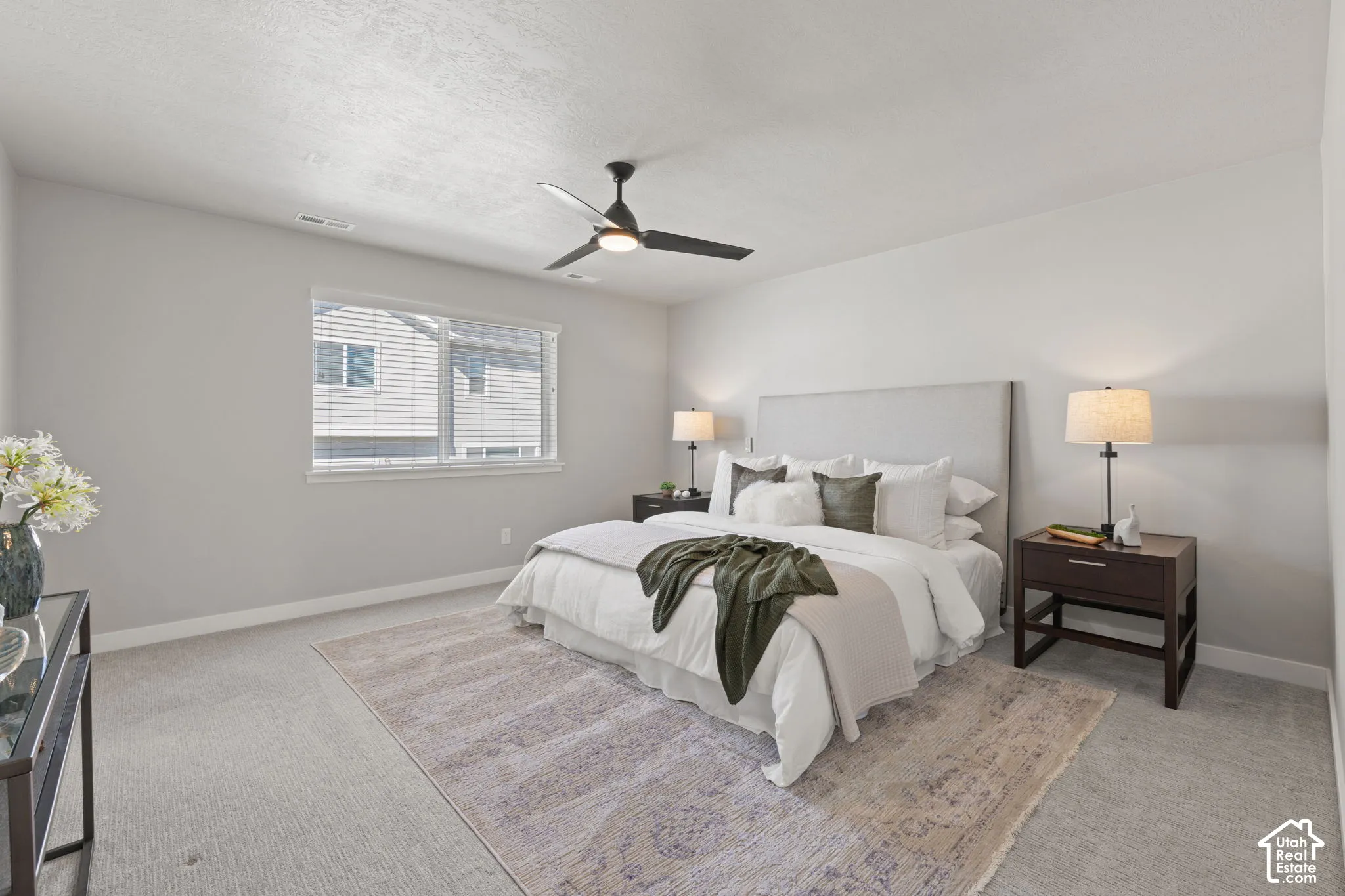 Carpeted room with a ceiling fan, a window with blinds, and light-colored walls