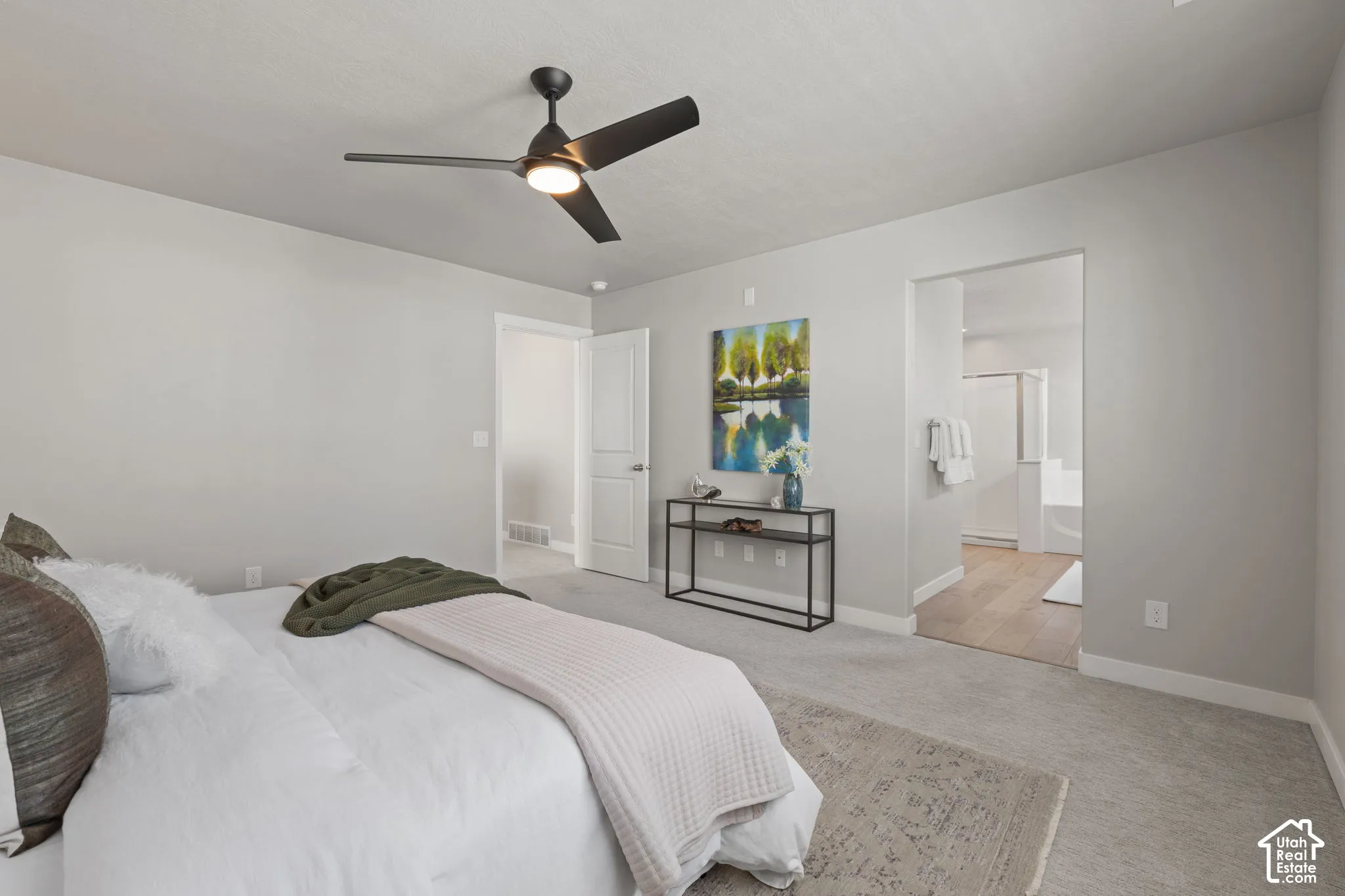 Bedroom featuring a ceiling fan with integrated lighting, light gray wall paint, and a carpeted floor