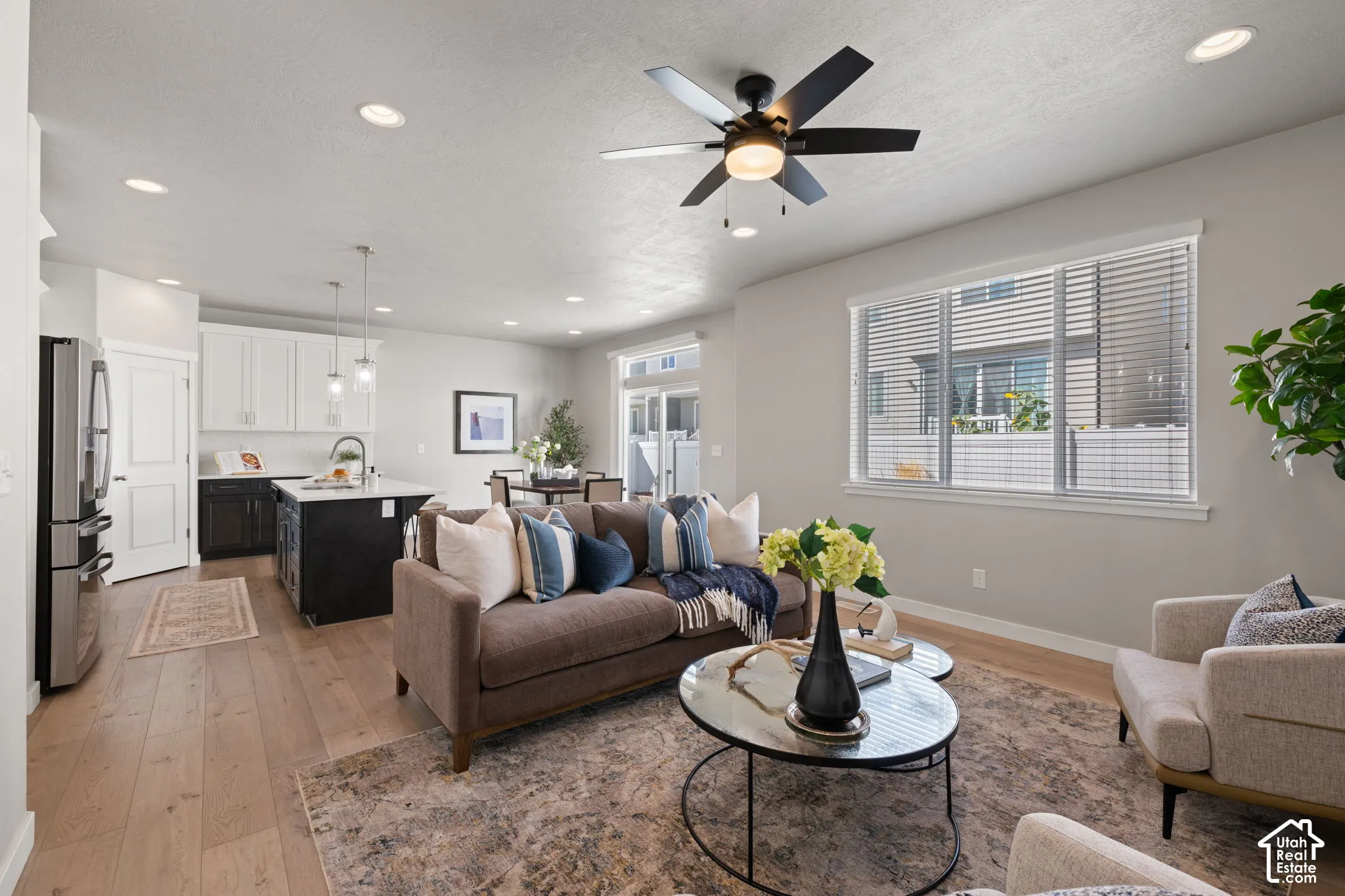 Open-concept living space featuring wood-finish flooring, recessed lighting, and a ceiling fan