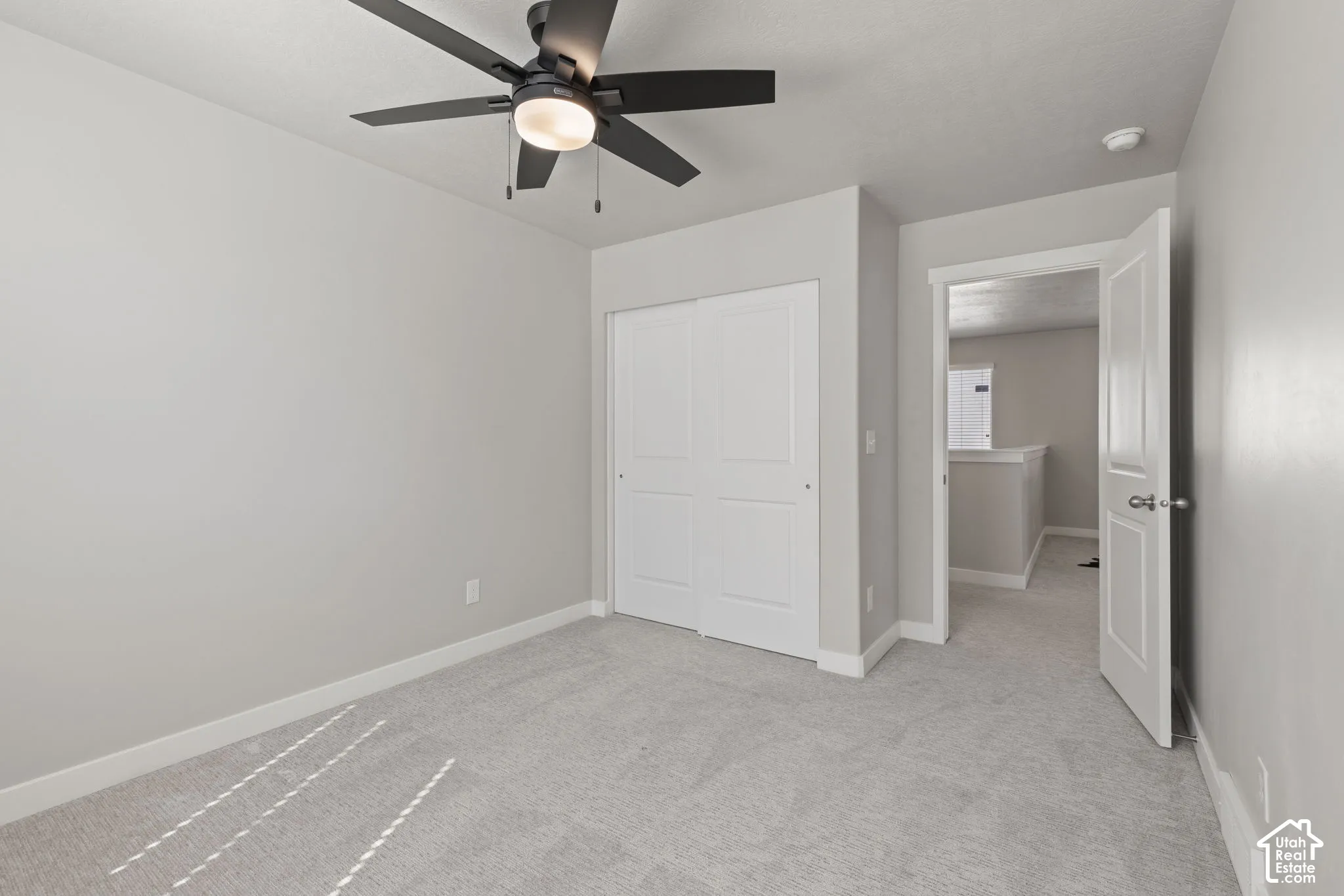 Recessed lighting, ceiling fan with integrated light, light gray wall paint, white bi-fold closet doors, and gray carpet