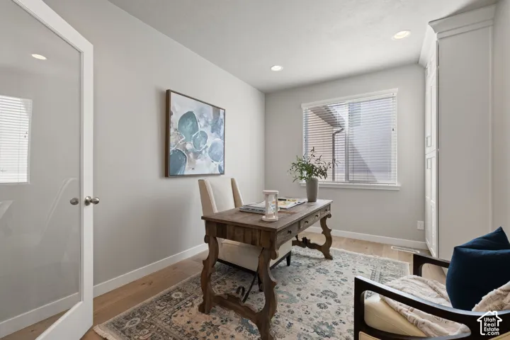 Recessed lighting, wood-finish flooring, and a window with blinds