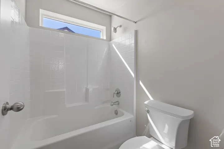 White tile-surround bathtub and shower with chrome fixtures