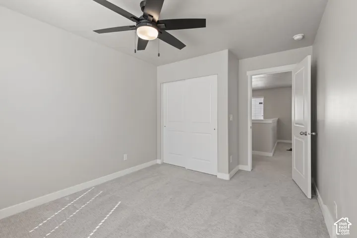 Recessed lighting, ceiling fan with integrated light, light gray wall paint, white bi-fold closet doors, and gray carpet