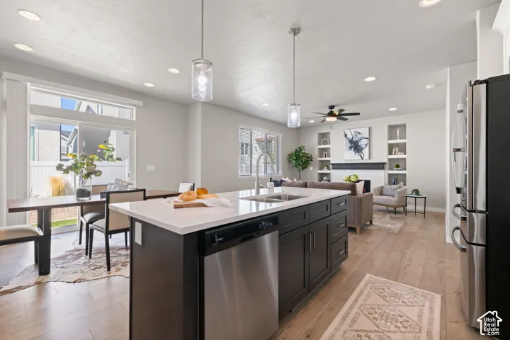 Open-concept living space featuring wood-finish flooring, recessed lighting, and a kitchen island with a white countertop