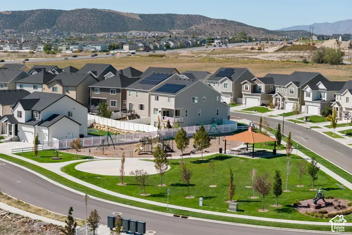 Community park featuring a playground structure, covered picnic area, and manicured green space