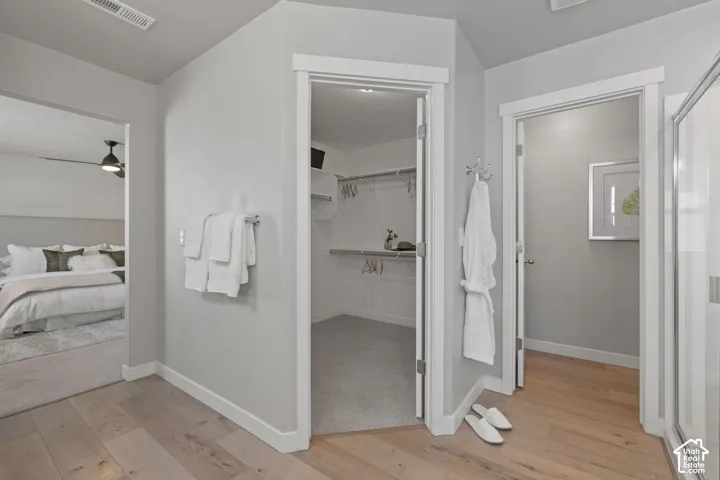 Wood-finish flooring, recessed lighting, and a walk-in closet with built-in shelving