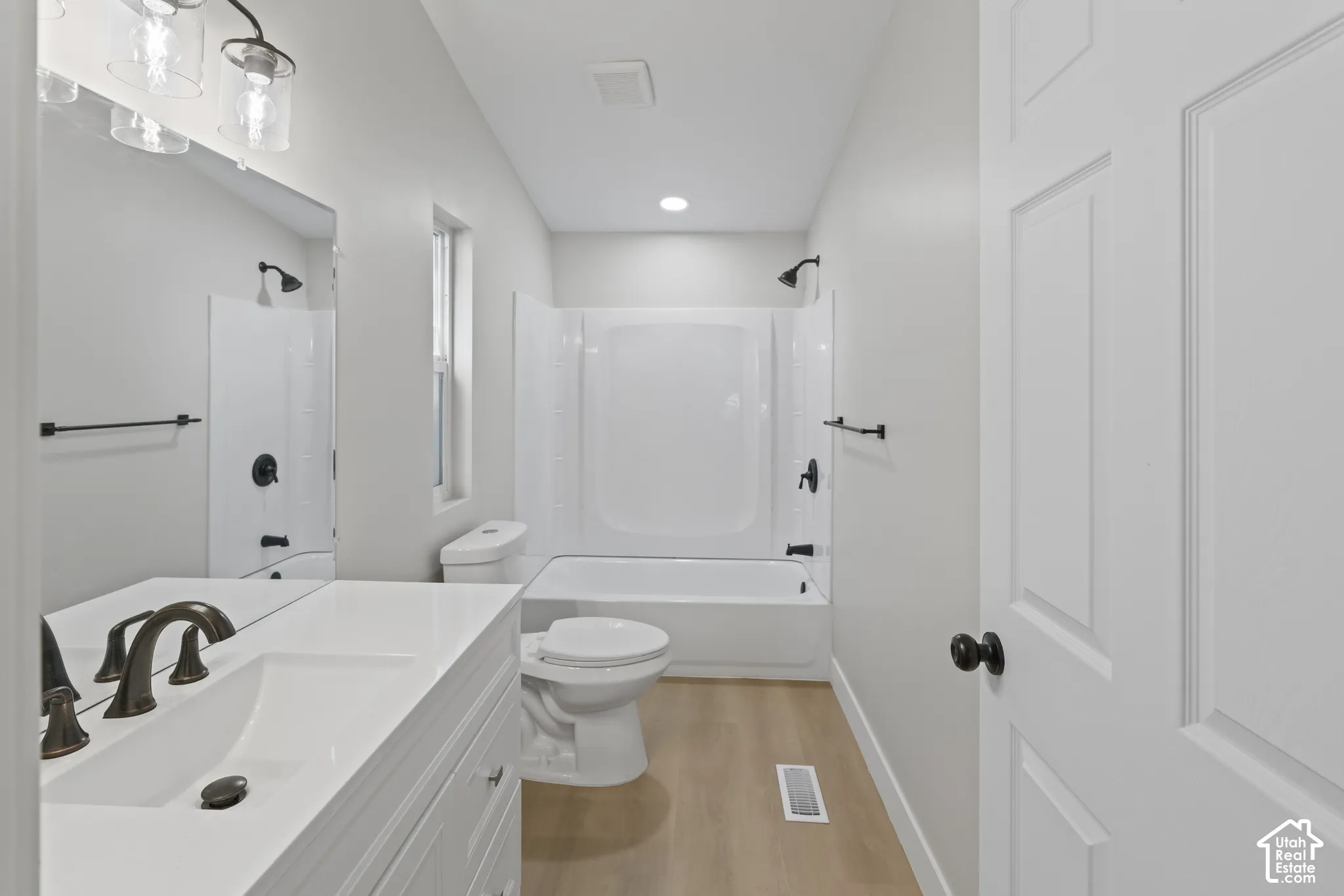 White vanity with an integrated rectangular sink and bronze-finish faucet