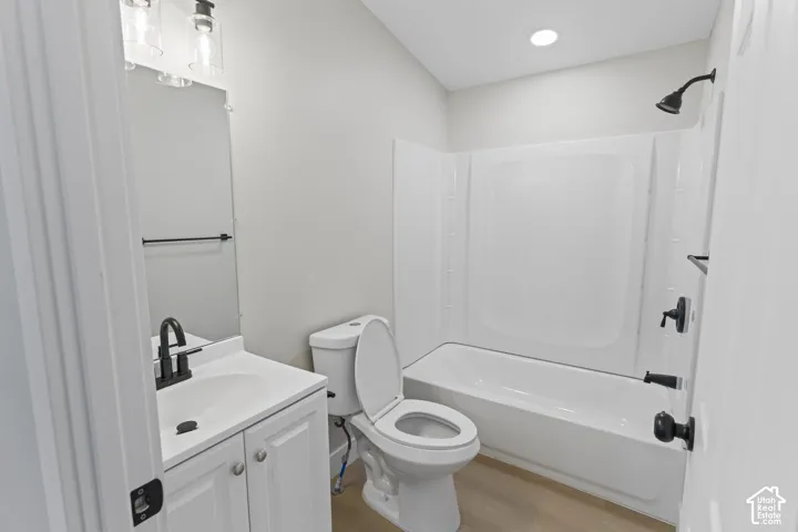 White vanity with a single basin sink, matte black faucet, and a two-light vanity fixture