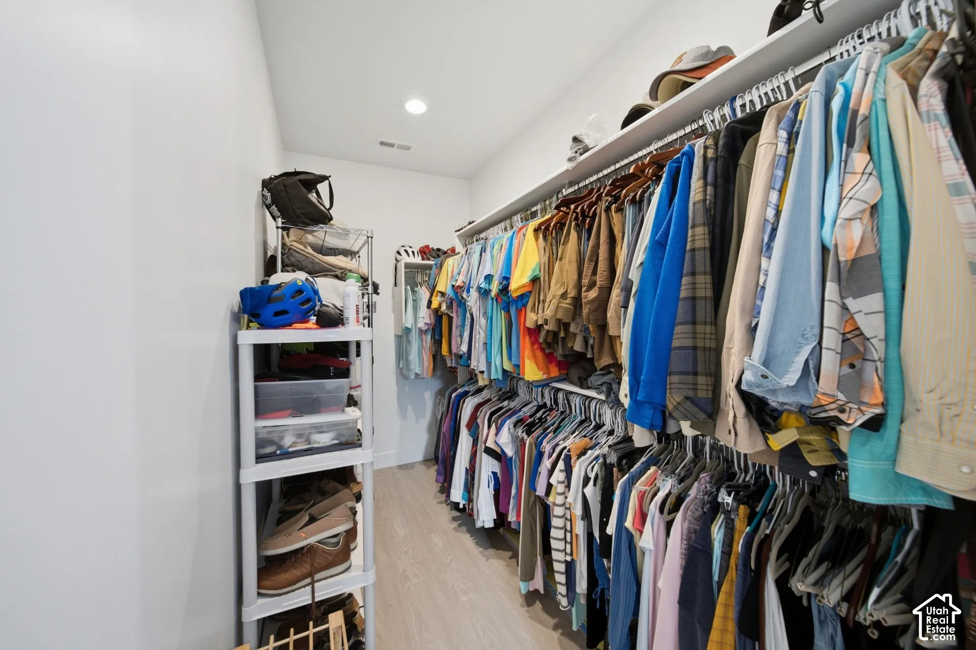Walk-in closet featuring light wood-finish flooring, recessed lighting, and white walls