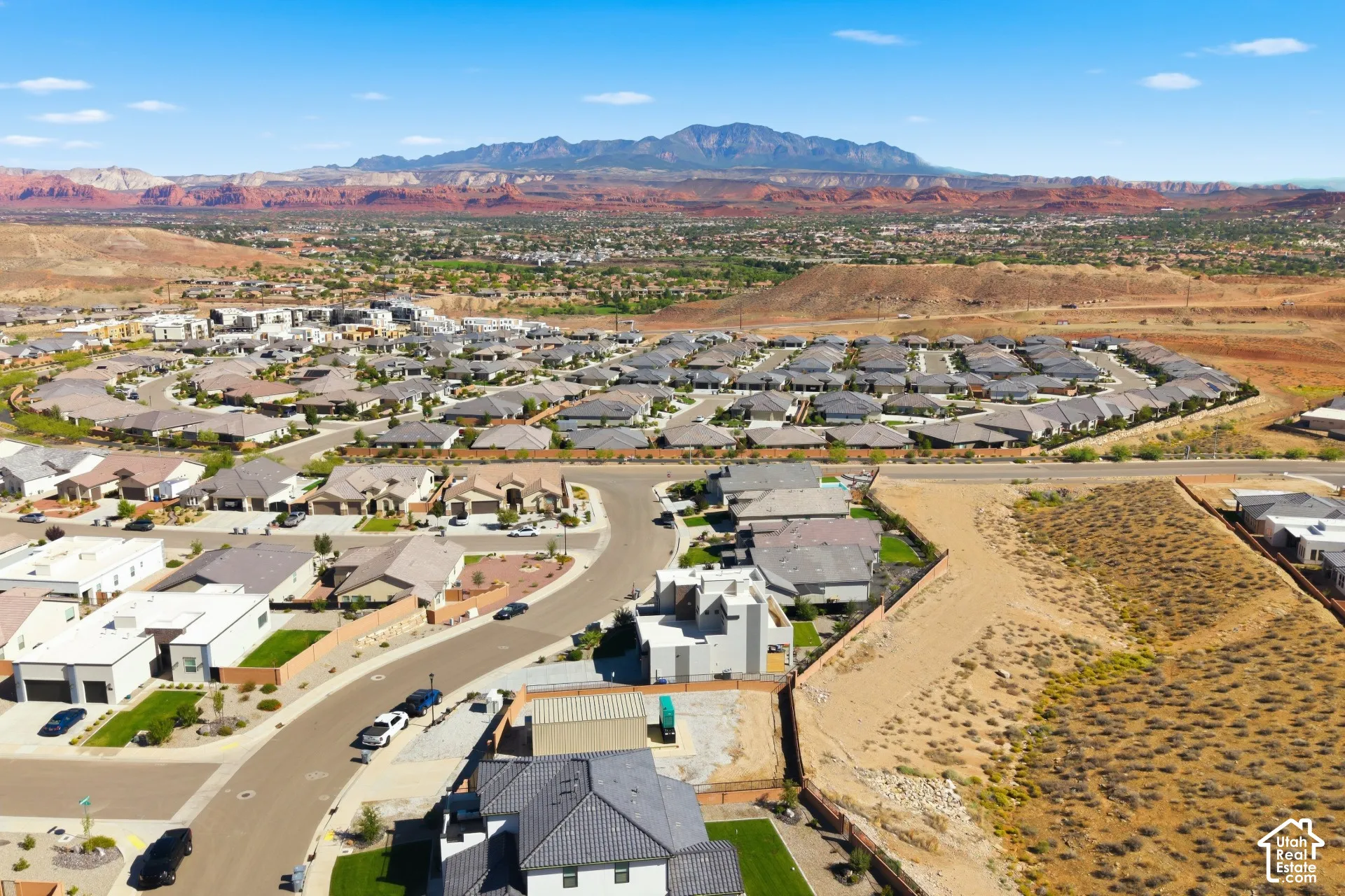 Expansive neighborhood with diverse architectural styles, surrounded by natural desert landscapes and distant mountains
