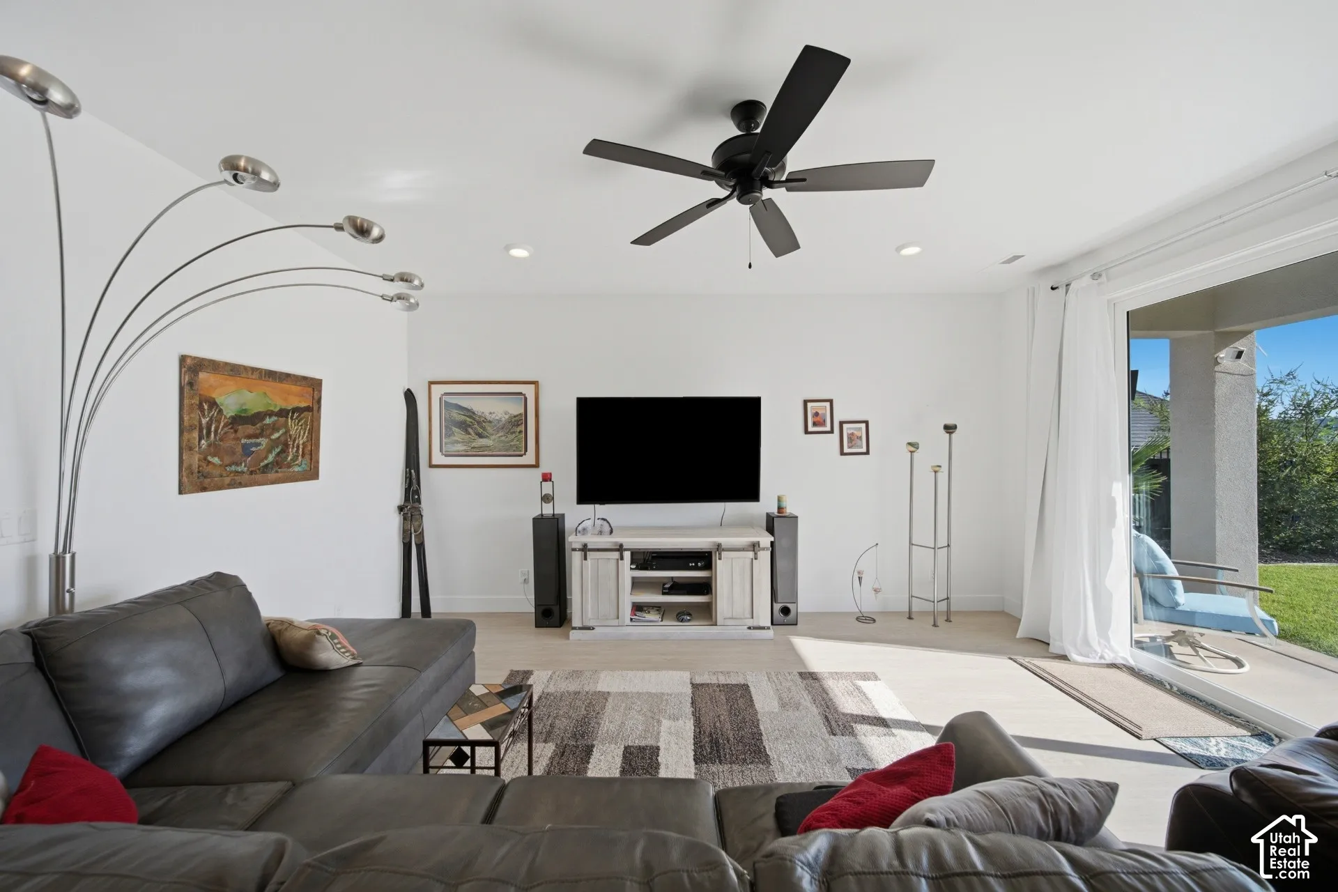 Recessed lighting, ceiling fan with black blades, light wood-finish flooring, sliding glass door, and covered patio